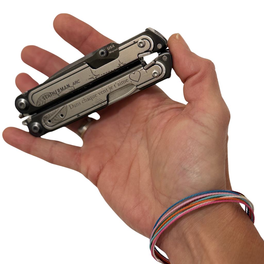 Multitool Leatherman tenu en main, utilisé comme outil polyvalent pour les réparations et gestes du quotidien à bord d’un bateau